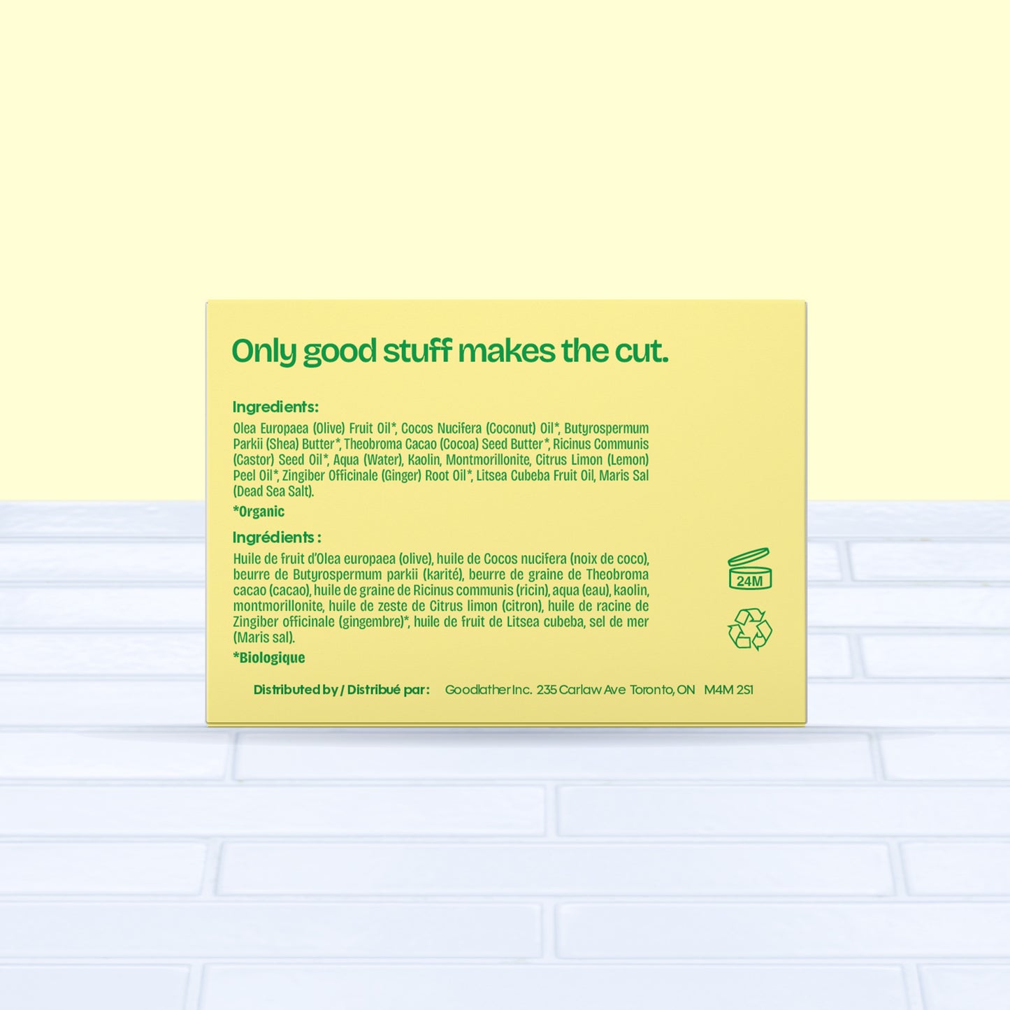 A bright yellow and green Goodlather Lemongrass and Ginger Bar Soap box sits on a light blue surface, showing ingredients in English and French, green text “Only good stuff makes the cut,” and eco-friendly icons for recycling and 24-month shelf life.