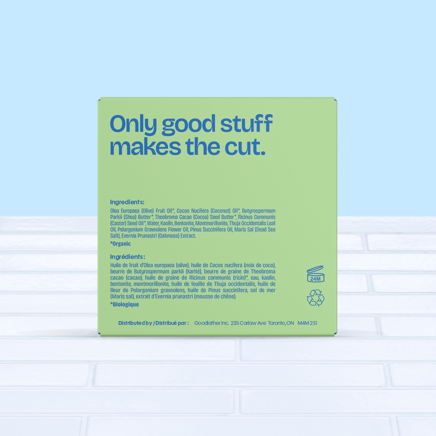 A square green and bright blue Goodlather Cedar Oakmoss Bar Soap box sits on white tile with a blue backdrop. Text reads "Only good stuff makes the cut," plus all natural ingredients and distribution details for this sustainable soap.