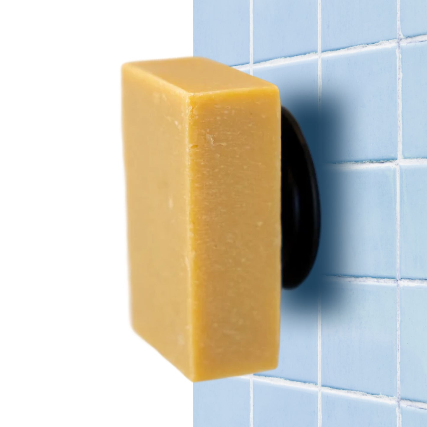 The Lemongrass and Ginger Goodlather soap bar is mounted vertically on a light blue tiled wall with a black and white Soapi Magnet Holder—an eco-friendly Canadian shower solution.